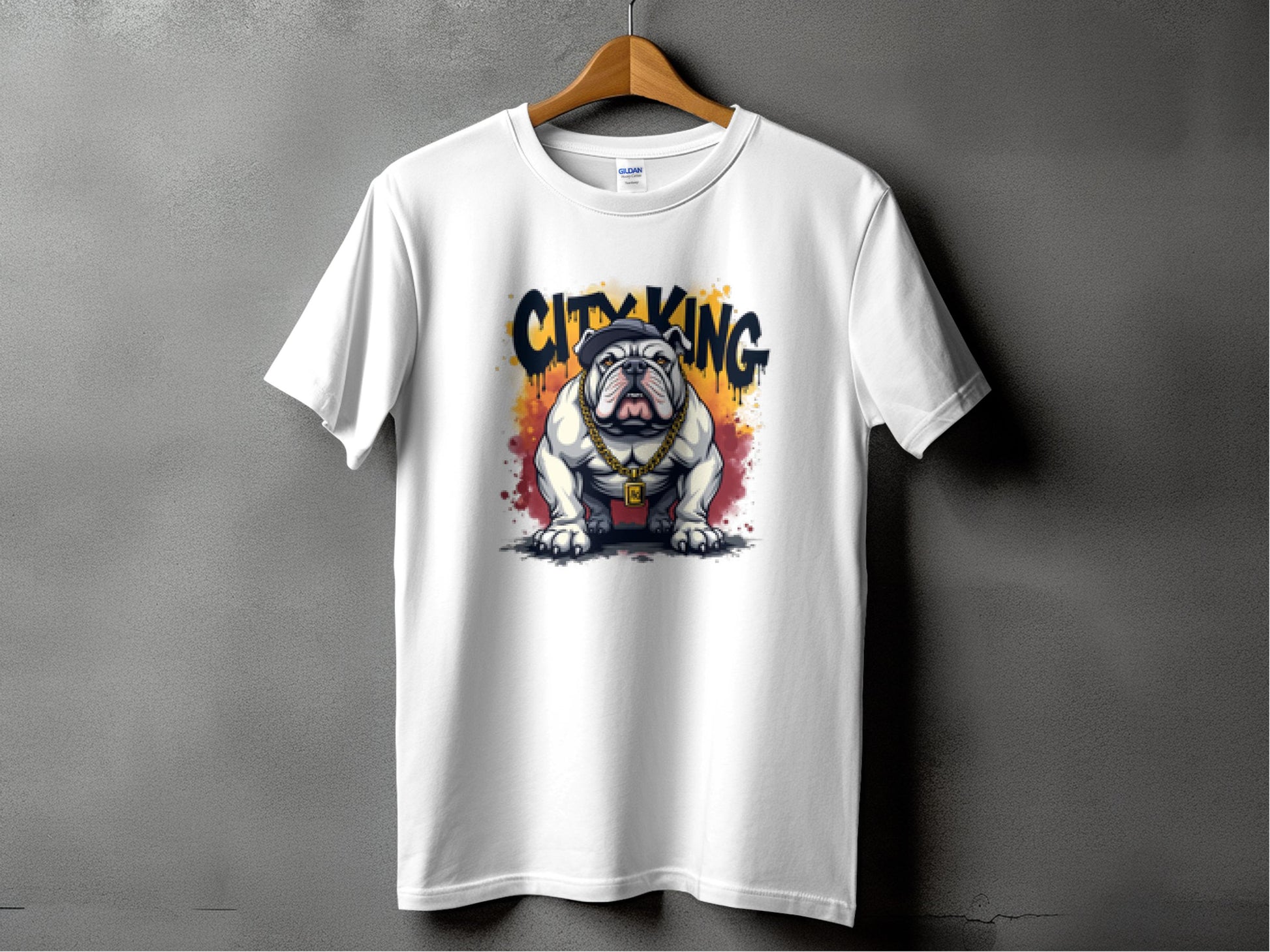 A white t-shirt from Garment Graphics City King collection hangs on a wooden hanger against a gray backdrop, showcasing a bulldog dressed royally with crown and robe, and the bold City King text above.