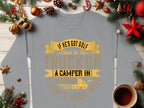 Garment Graphics offers a gray sweatshirt with the phrase If he’s got golf clubs in his truck or a camper in his driveway, dont hire him! in gold and yellow letters. Ideal for outdoor enthusiasts, its adorned with pine branches, ornaments, and coffee on a wooden table.