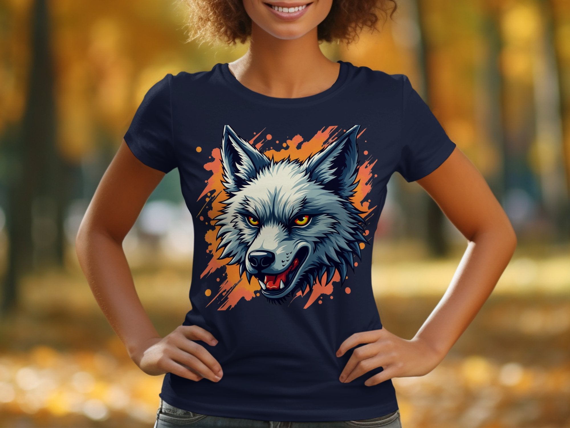 In a park, someone wears a Garment Graphics navy blue T-shirt featuring a fierce wolf head with yellow eyes and open mouth. The blurred autumn trees in the background, vibrant with orange and yellow leaves, enhance the scenes vividness—ideal for those with a daring personality.