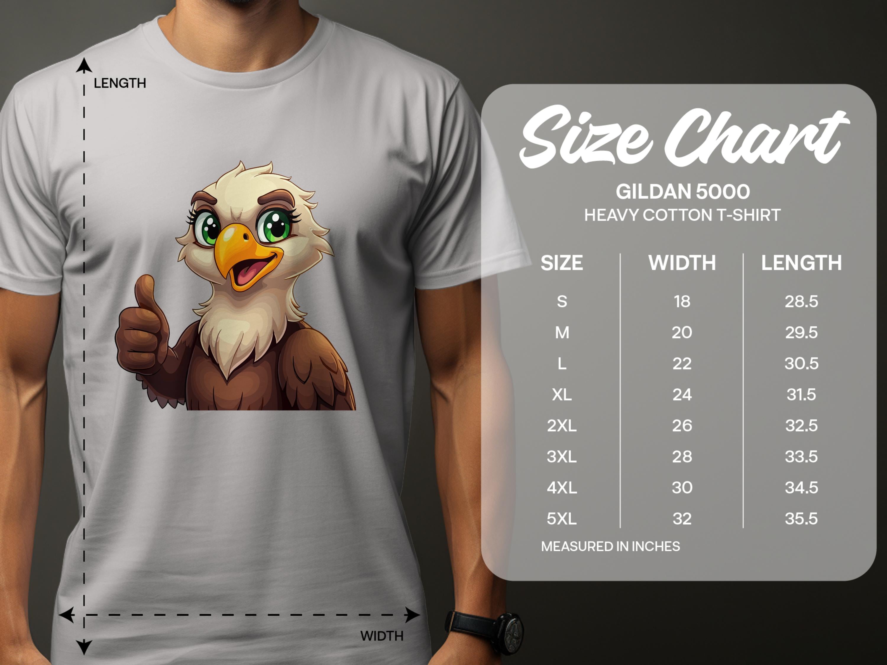 A person in a gray Garment Graphics Eagle T-shirt with a cartoon eagle giving a thumbs up adds flair to casual wear. The tee is made from Gildan 5000 heavy cotton, available in sizes S to 5XL, each with specific width and length measurements.