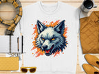 The Garment Graphics white t-shirt features a fierce wolf graphic with sharp yellow eyes and an open mouth, accented by bold orange splatters. Accompany it with a scarf, notebook, pen, yellow clutch, sunglasses, cup, and a yellow jacket for a bold look that embraces your wild side.