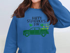 A person with long, dark brown hair is wearing a festive Garment Graphics sweatshirt featuring a green truck and shamrocks, adorned with the text Happy St. Patricks Day.