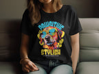 A person wears a black Dog T-Shirt by Garment Graphics, featuring a colorful dog with sunglasses. The text reads, Pawsitive Stylish Chillax like a canine villain. This relaxed and stylish design is tailored for womens sizing with part of their face visible.