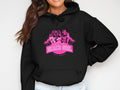 A person is wearing a casual black hoodie from Garment Graphics, featuring a vibrant pink graphic design of three women in swimsuits with palm trees, alongside the text Always Party Beach Girl.