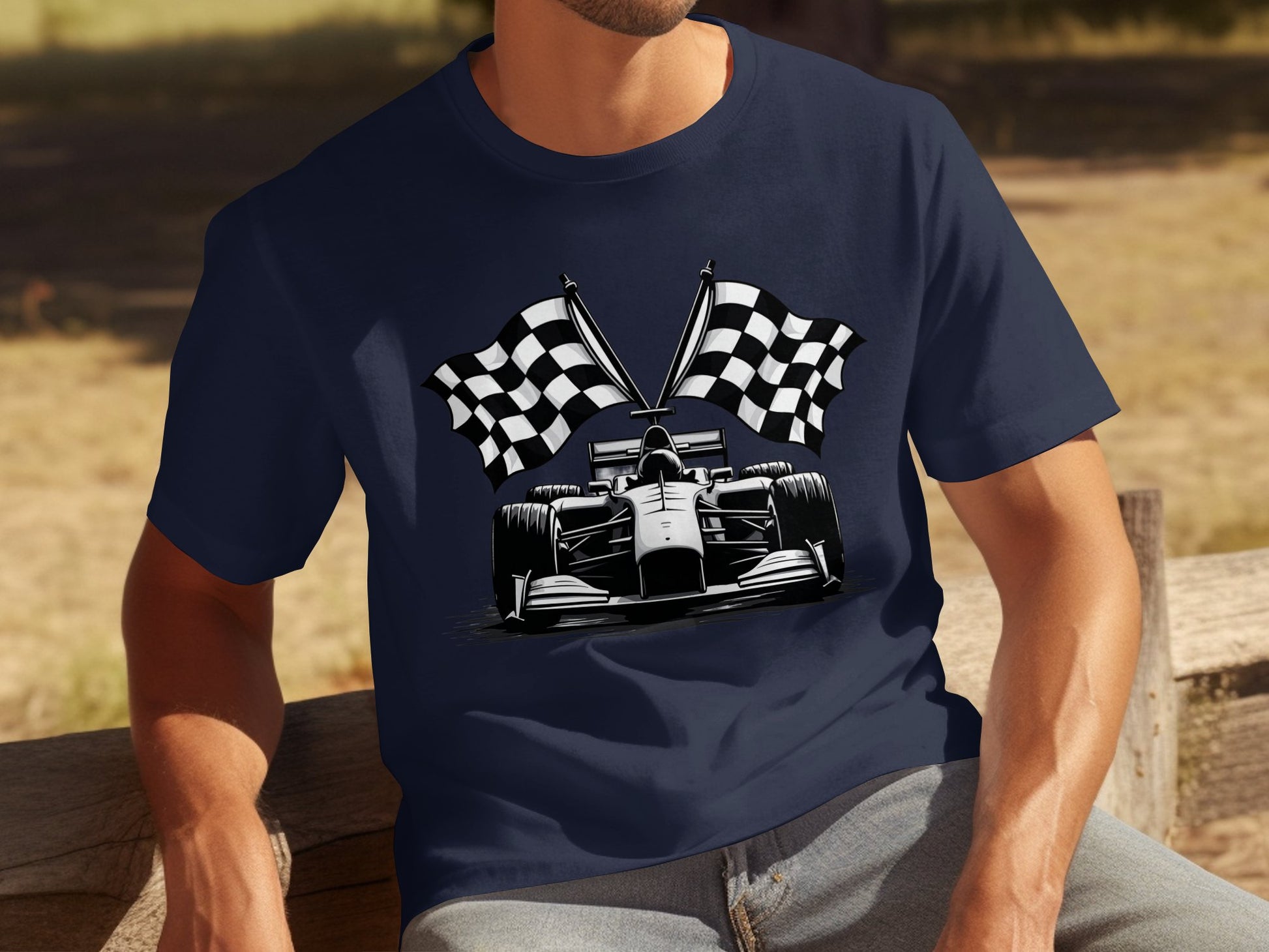 A man relaxes on a wooden bench surrounded by greenery, wearing a navy blue Garment Graphics T-shirt featuring a Formula 1 car with crossed checkered flags, embodying the spirit of motorsport.