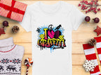 Garment Graphics offers a white t-shirt with vibrant street art, featuring I love Graffiti text with a heart and spray cans. Ideal for urban design lovers, its shown amid wrapped gifts, pinecones, a sweater, a candy cane, and holiday decorations on a wooden surface.