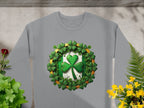 Gray Garment Graphics sweatshirt features a central four-leaf clover encircled by shamrocks, with green and yellow plant designs on a stone-like background—perfect for celebrating the Irish spirit.