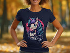 A person wearing a Garment Graphics navy blue I Love My Pony T-shirt with a vibrant unicorn graphic stands against a blurred autumn backdrop of orange and yellow leaves—ideal for unicorn enthusiasts.