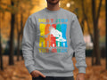 In a park with autumn trees, a person wears a light gray Garment Graphics sweatshirt adorned with a DJ silhouette and Dont Stop the Music, perfect for music lovers in unisex sizing.
