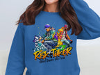 A person is wearing a blue sweatshirt from Garment Graphics, featuring a vibrant graphic of two dancers and bold text saying Risk Taker with Street Dance Finals 10th Edition, celebrating the spirit of street dance finals.