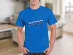 A person wears a bright blue t-shirt from Garment Graphics with RETRO printed on the front, exuding vintage charm. The background is a blurred interior, hinting at a classic fit in a cozy living room with furniture.