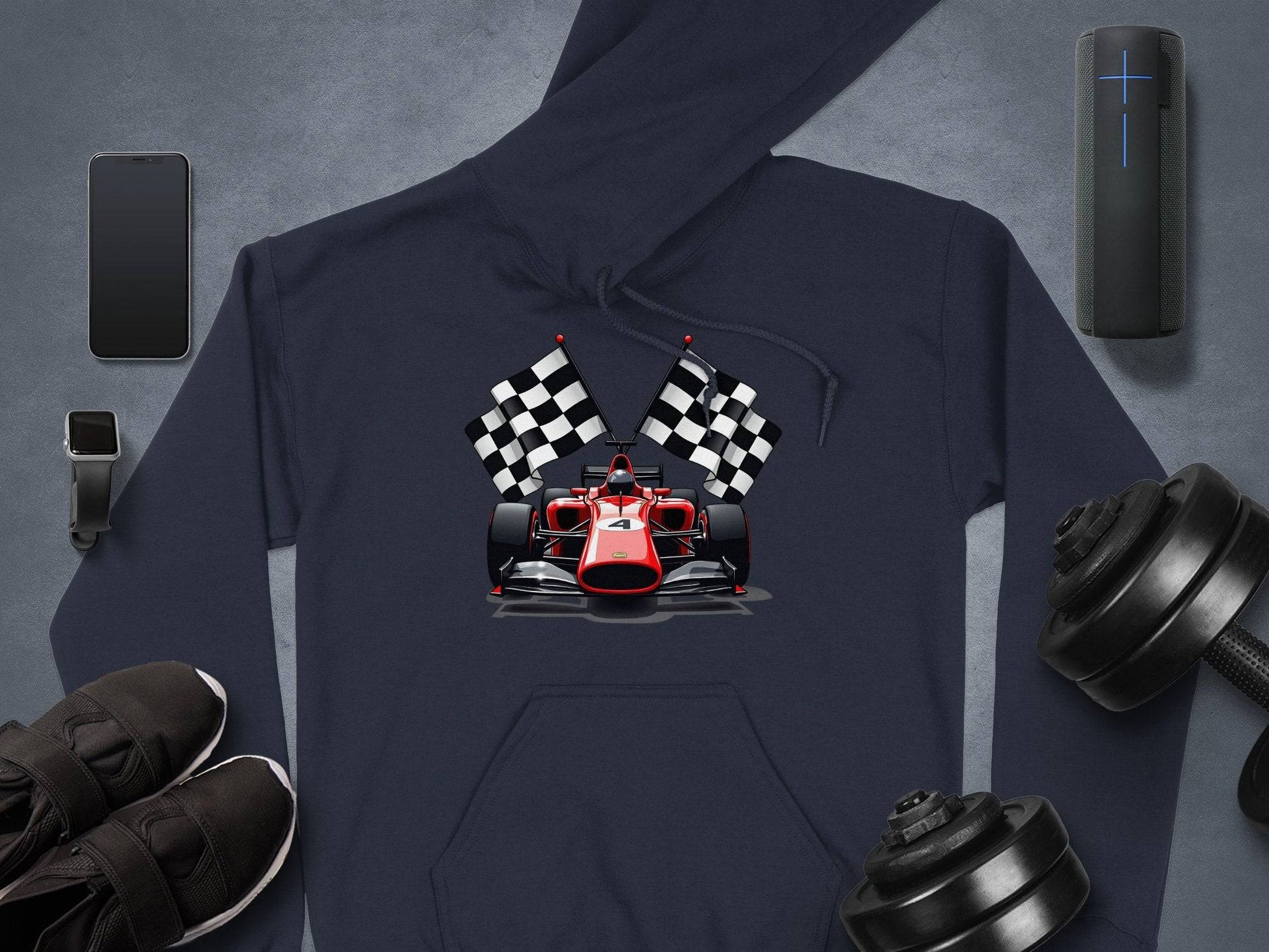 Garment Graphics presents a stylish navy hoodie featuring a red racing car with checkered flags, surrounded by a smartphone, smartwatch, portable speaker, black sneakers, and adjustable dumbbells on a sleek gray surface.