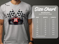 A motorsport fan wears a Garment Graphics white t-shirt featuring a red race car and two checkered flags. The size chart for these stylish Gildan 5000 T-shirts lists sizes S to 5XL with width and length measurements in inches.
