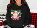 A woman wears a Garment Graphics Bold Statement Hoodie featuring a cowgirl, flowers, and HANDS OFF! text in vivid green and red. She is seated on a black and red plaid blanket with Christmas-themed decorations around her.