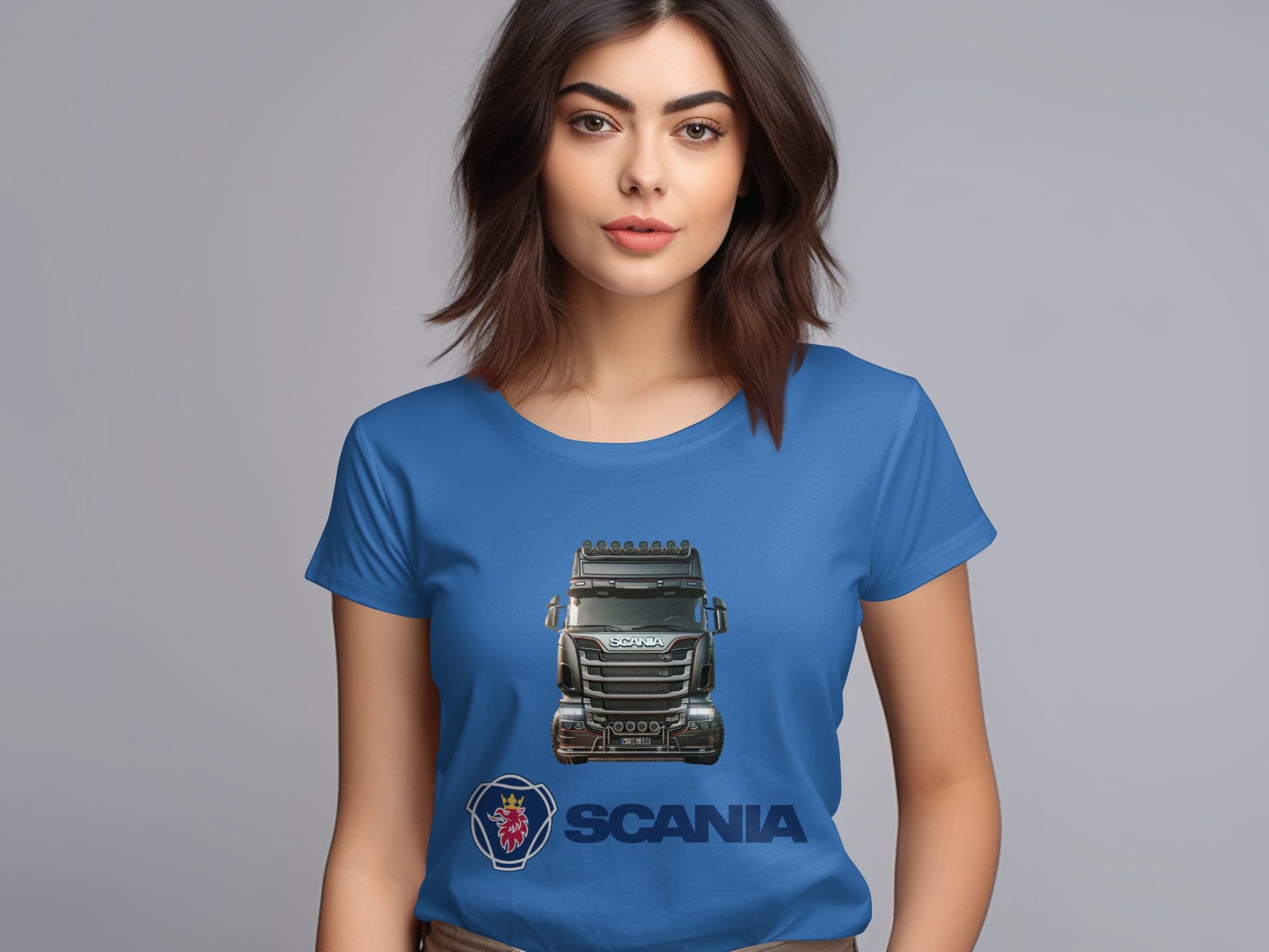 A woman with long brown hair wears a vibrant Garment Graphics T-shirt featuring a Scania truck and logo. Ideal for automotive fans, she stands against a gray background, gazing forward.