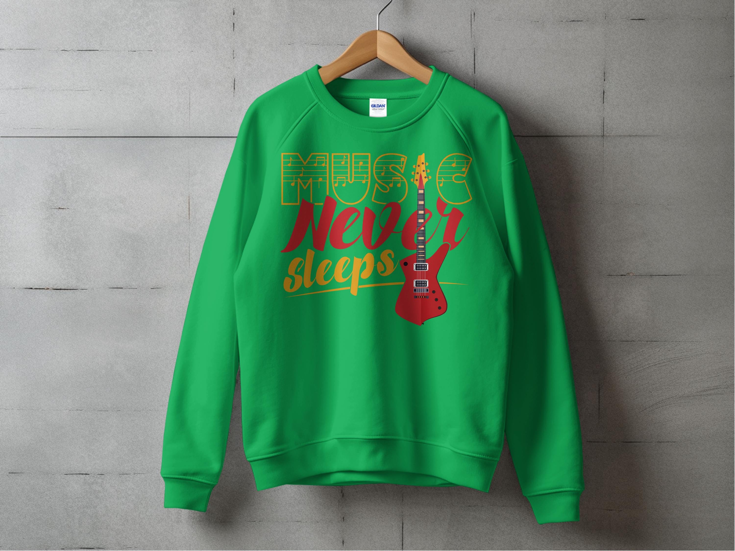 The Garment Graphics sweatshirt, in vibrant green, features Music Never Sleeps printed in yellow and red with an electric guitar graphic. Designed for music lovers, it hangs on a wooden hanger against a concrete wall backdrop.