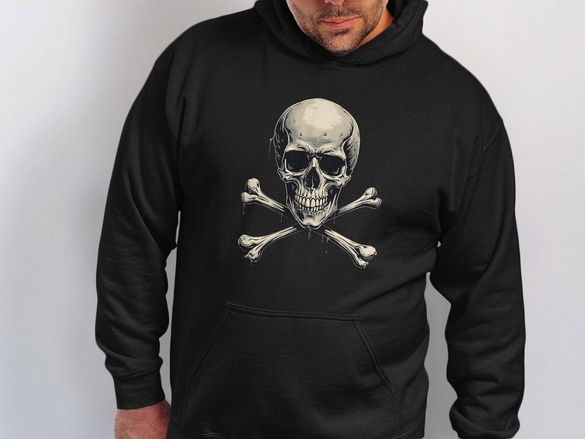 A person exudes style in a Garment Graphics black hoodie featuring a bold skull and crossbones design against a plain white backdrop.