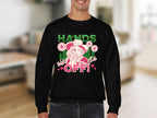 A man wears a black Garment Graphics Wild Side Sweatshirt featuring bold cartoon character graphics, including a flowered hat and the text Hands off! and Wild girl. This unisex sweatshirt stands out against the blurred indoor backdrop.