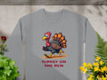 The Garment Graphics gray sweatshirt, designed for unisex sizing, showcases a humorous cartoon turkey on the run. Its complemented by green and yellow plants and a red flower on the left, adding charm to this funny graphic design.