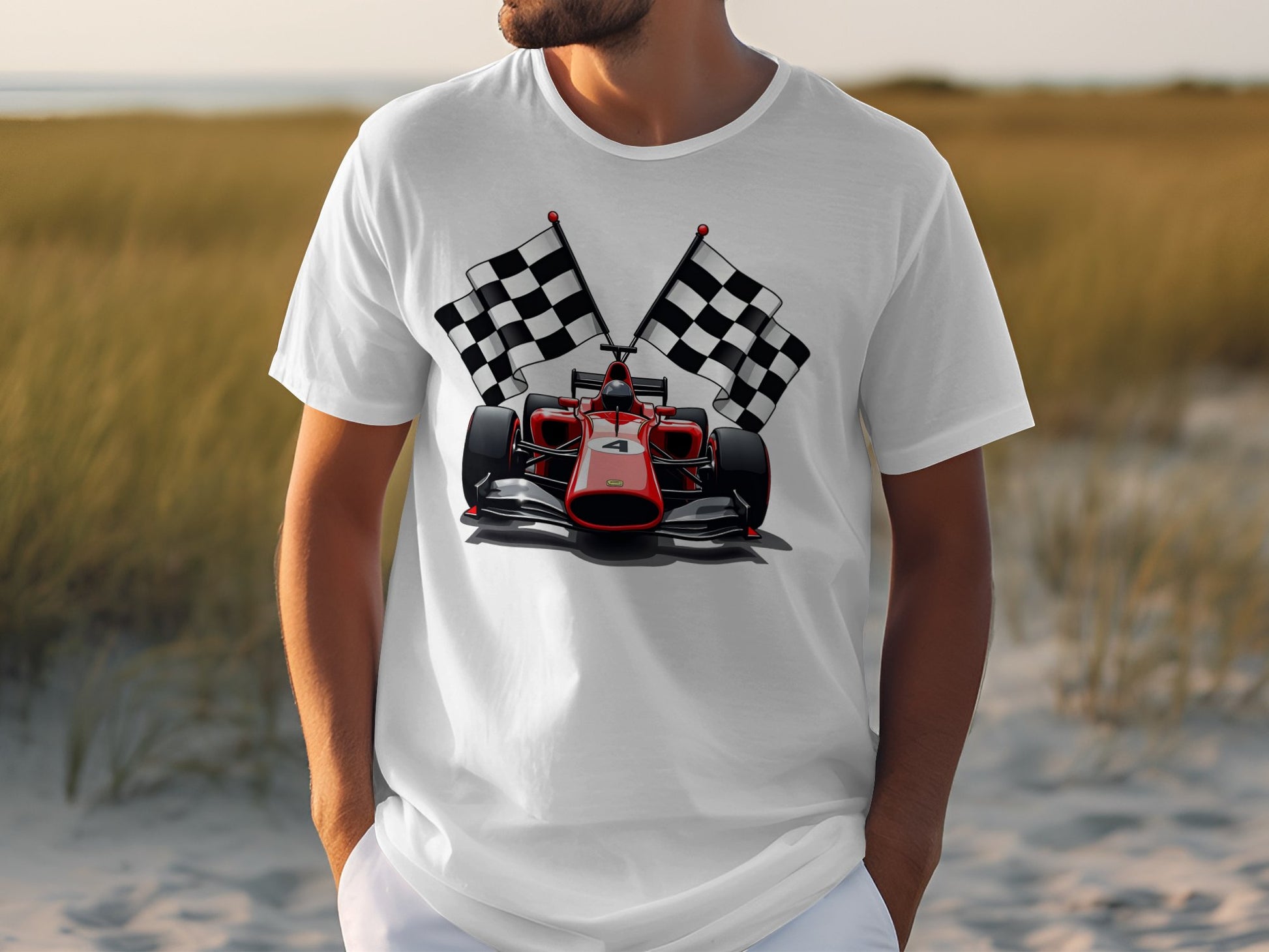 A person is wearing a Garment Graphics white T-shirt featuring a red racing car and two checkered flags, set against sandy terrain and tall grass, capturing the thrilling spirit of motorsport.