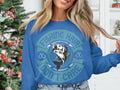 A fishing enthusiast stands by a Christmas tree, wearing a Garment Graphics blue sweatshirt with a fish graphic and the phrase Fishing Hair Dont Care, accented by anchors.