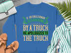 This blue sweatshirt by Garment Graphics features a bold, humorous design: If an Englishman gets run down by a truck he apologizes to the truck. It offers unisex sizing for a perfect fit and is styled with nearby items including a green striped shirt and brown sandals on a gray backdrop.