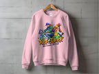 A pink sweatshirt from Garment Graphics features bold Risk Taker, Street Dance 10th Final text with vibrant street dance graphics of two people in dynamic poses wearing streetwear and caps. This urban style piece, in unisex sizing, is showcased against a concrete wall.