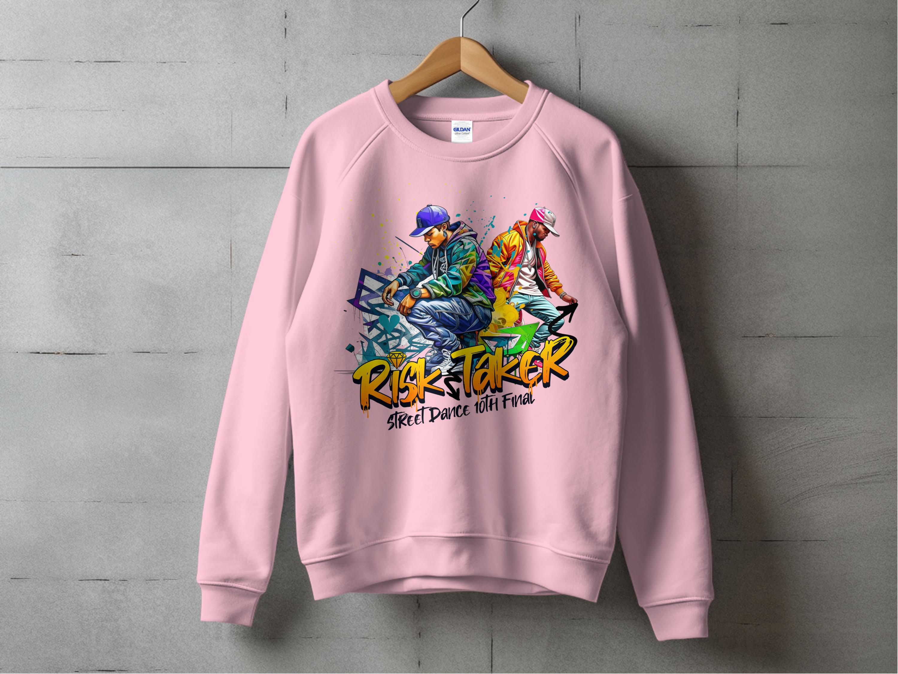 A pink sweatshirt from Garment Graphics features bold Risk Taker, Street Dance 10th Final text with vibrant street dance graphics of two people in dynamic poses wearing streetwear and caps. This urban style piece, in unisex sizing, is showcased against a concrete wall.