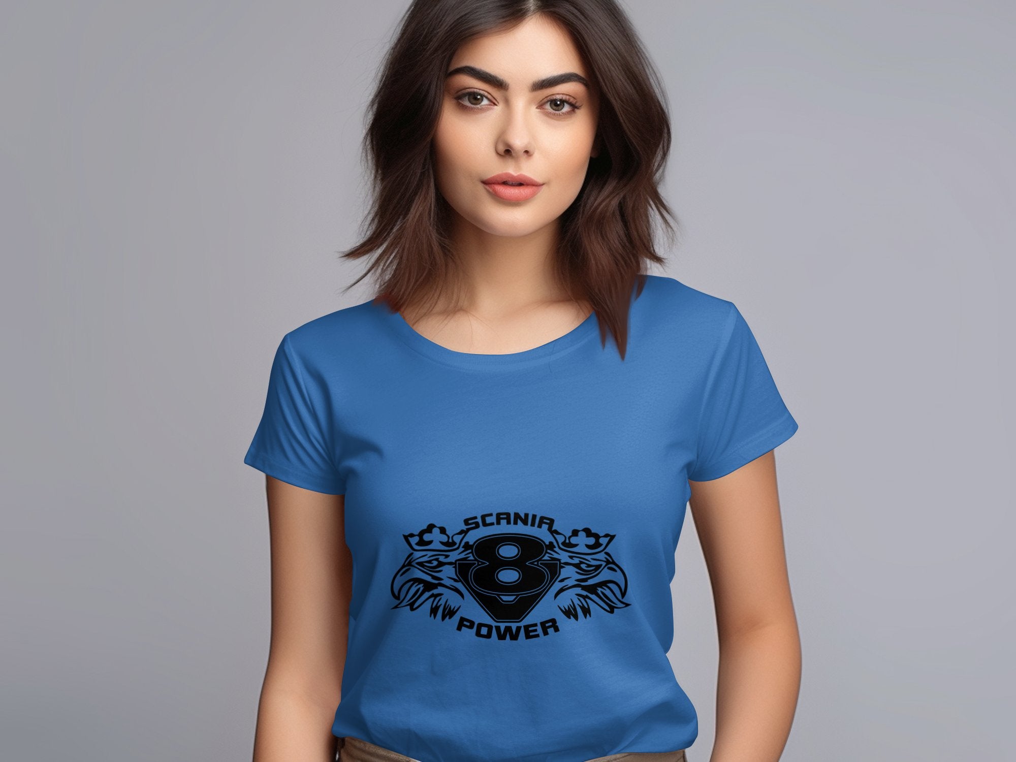 A dark-haired woman wears a blue Garment Graphics T-shirt with Scania V8 Power and eagle head graphics, set against a plain gray background.