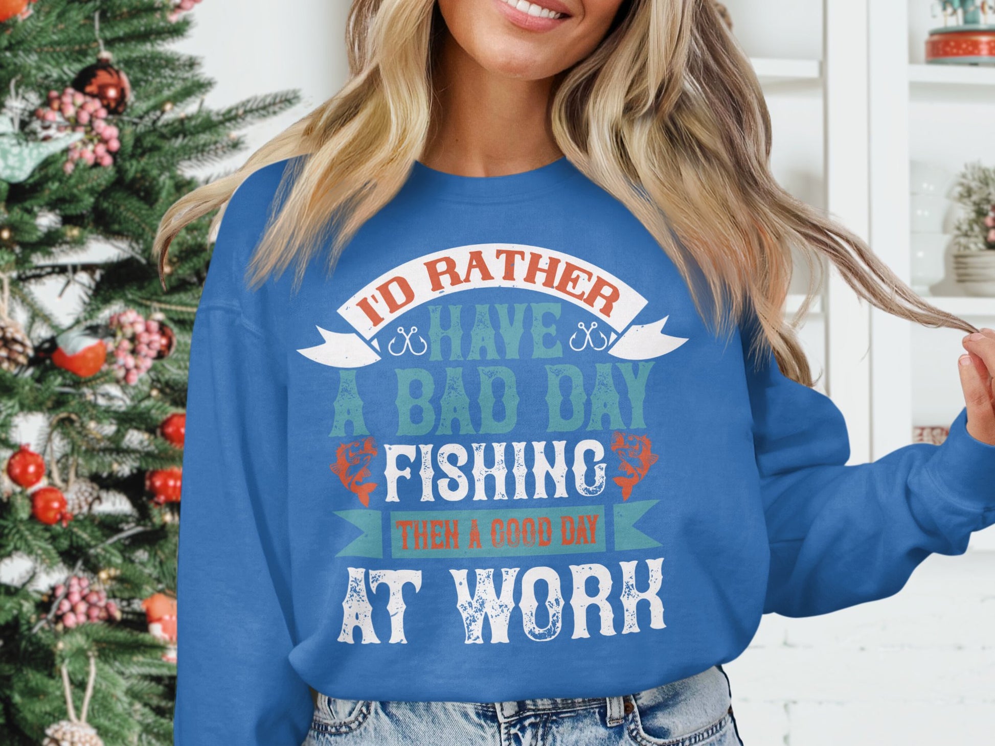 A person in a Garment Graphics Unisex Fishing Sweatshirt with Id rather have a bad day fishing than a good day at work is next to an ornately decorated Christmas tree, making it the ideal Fishing Passion Apparel for the holiday season.