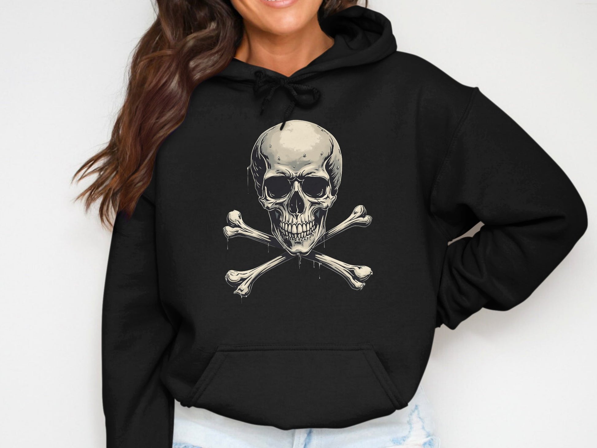 A person in a black Skull and Crossbones hoodie from Garment Graphics edgy streetwear collection smiles confidently with long, wavy brown hair against a plain background.