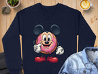 This cozy Garment Graphics unisex navy blue sweatshirt features a cheerful donut character with mouse-like ears and red shoes. Perfectly paired with a denim jacket, its set against a wooden background with a steaming cup of coffee nearby.