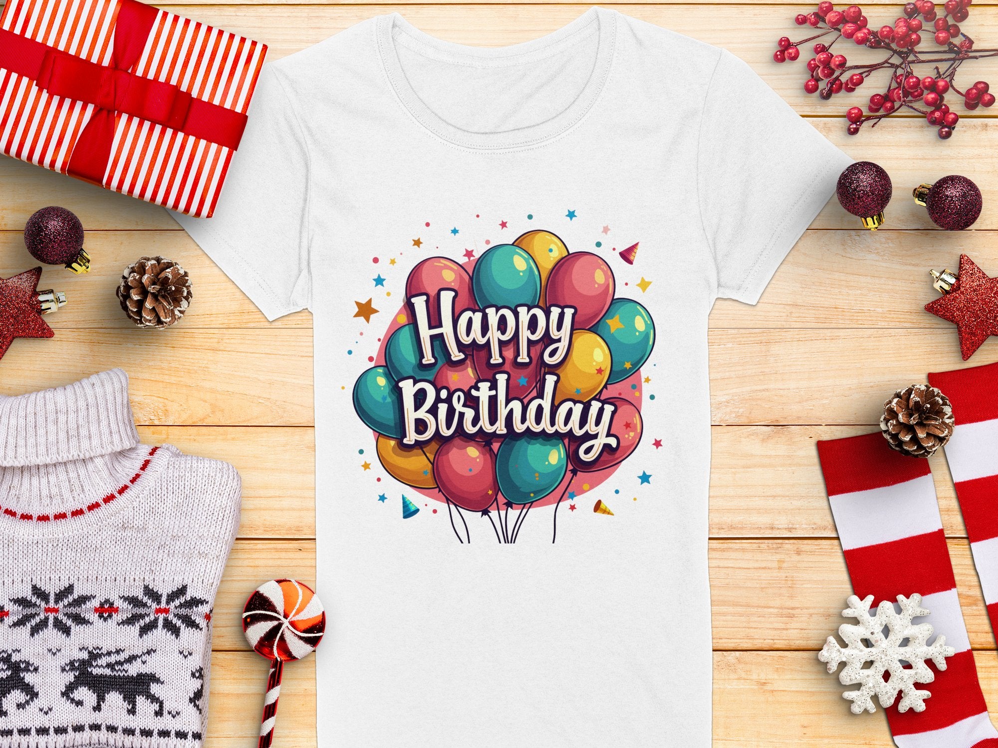 The vibrant white t-shirt from Garment Graphics is perfect for a birthday celebration. It features a colorful balloon graphic and Happy Birthday text, crafted from 100% cotton, making it an ideal match for festive items like wrapped gifts and red ornaments.