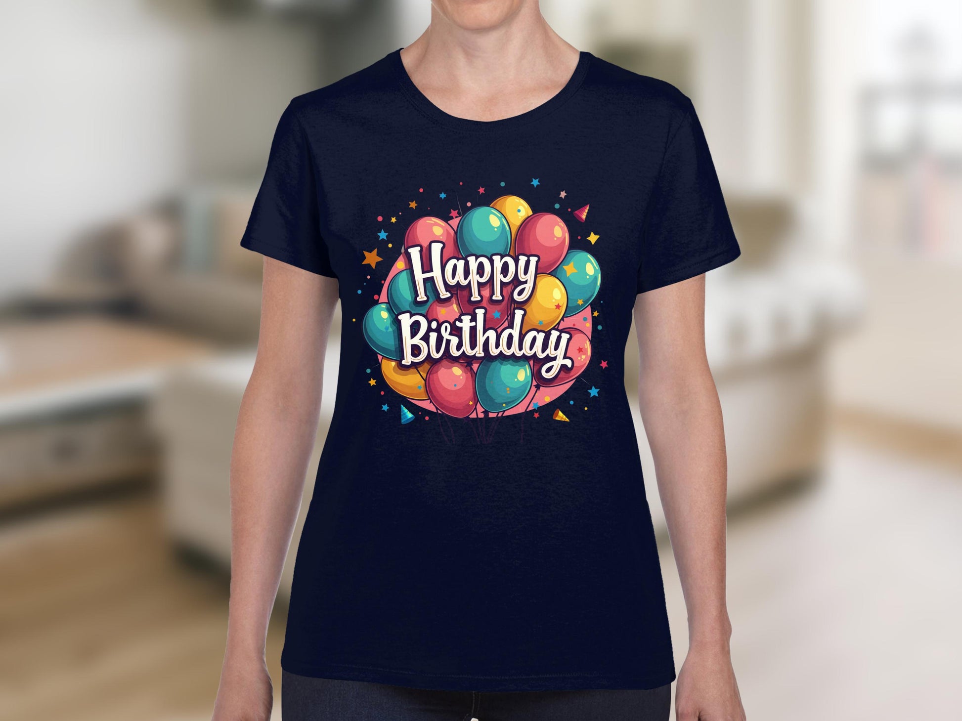 A person wearing a vibrant dark blue Garment Graphics t-shirt, made of 100% cotton and adorned with colorful balloons and the text Happy Birthday, stands indoors at a lively birthday celebration with a blurred background.