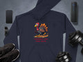 The navy hoodie by Garment Graphics showcases a cartoon turkey sprinting above Turkey On The Run, with dynamic elements like a smartphone, smartwatch, earbuds, wireless speaker, sneakers, and dumbbells. Ideal for those who love funny hoodies with a tech-savvy flair!.