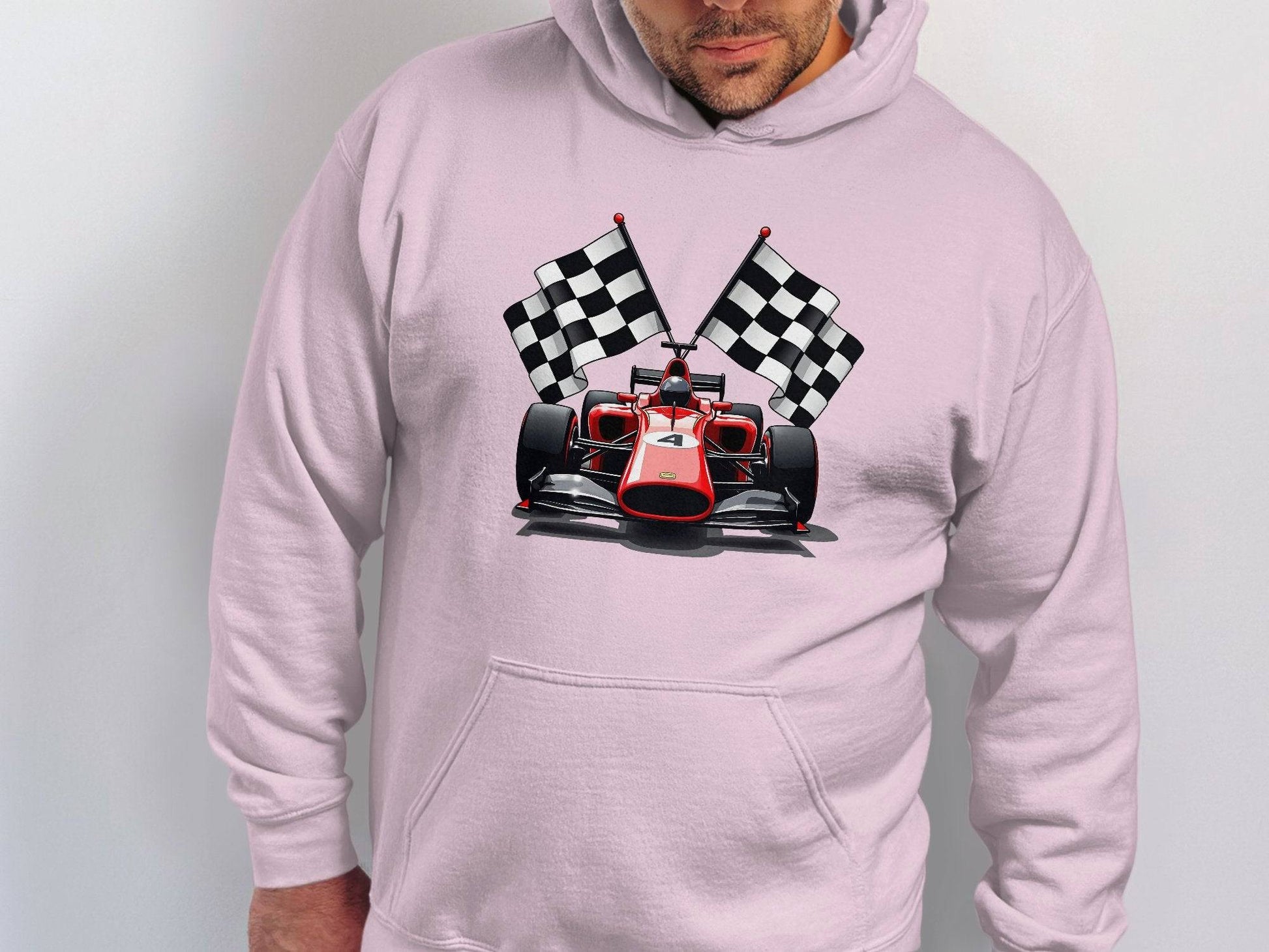 Dressed in a stylish light gray Garment Graphics hoodie featuring a red racing car with two crossed checkered flags, an individual stands confidently, facing the camera. One hand is tucked into a pocket while the other is partially visible.