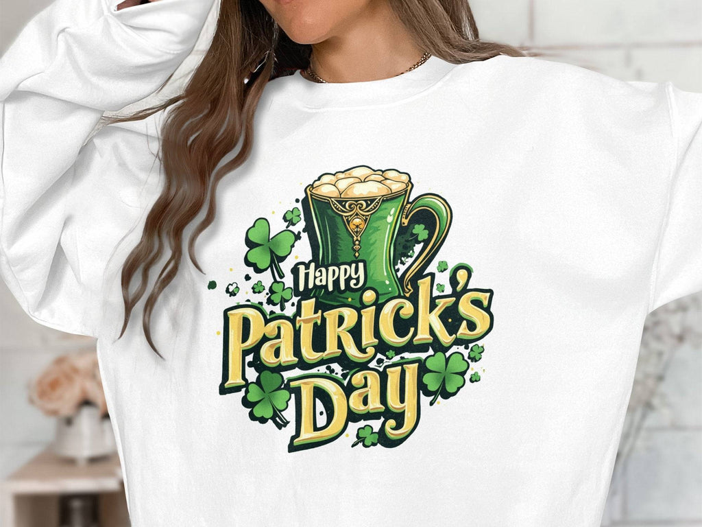 A person models a vibrant Garment Graphics sweatshirt featuring Happy Patricks Day in green and gold letters, with a design of a green frothy beer mug and shamrocks. The face of the person is not visible as they celebrate St. Patricks Day.