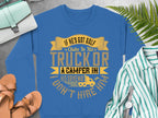 Garment Graphics blue humor sweatshirt says, If hes got golf clubs in his truck or a camper in his driveway I dont hire him, with a camper graphic. Nearby are casual items like sandals, a striped shirt, ferns, and a light blue crossbody bag.