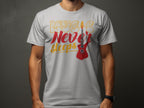 A person wears a Garment Graphics T-Shirt featuring Music Never Sleeps in bold on its light gray, 100% cotton fabric. The design highlights a vibrant red electric guitar against a dark, neutral backdrop.