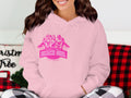 A person wears a vibrant Always Party Beach Girl hoodie with cartoon women and palm trees by Garment Graphics. They sit casually with a black-and-red plaid blanket nearby, while a Christmas tree twinkles in the background.