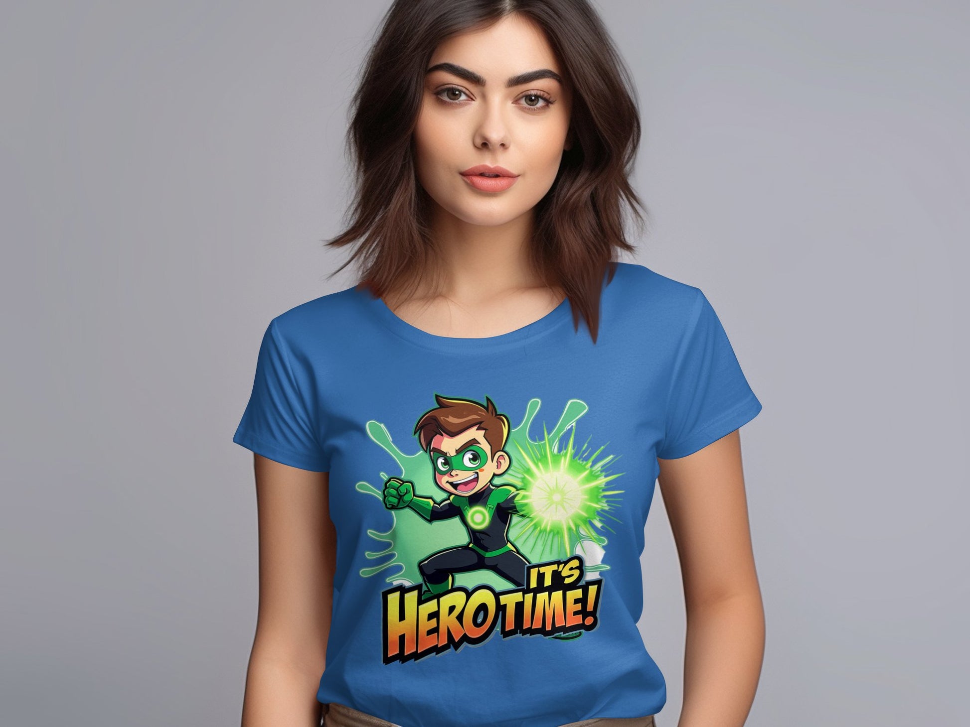 A woman wears a blue ITS HERO TIME! t-shirt by Garment Graphics, featuring a vibrant green superhero with spiky hair and a confident expression. Her long dark hair and neutral look perfectly match the bold colors of her attire.