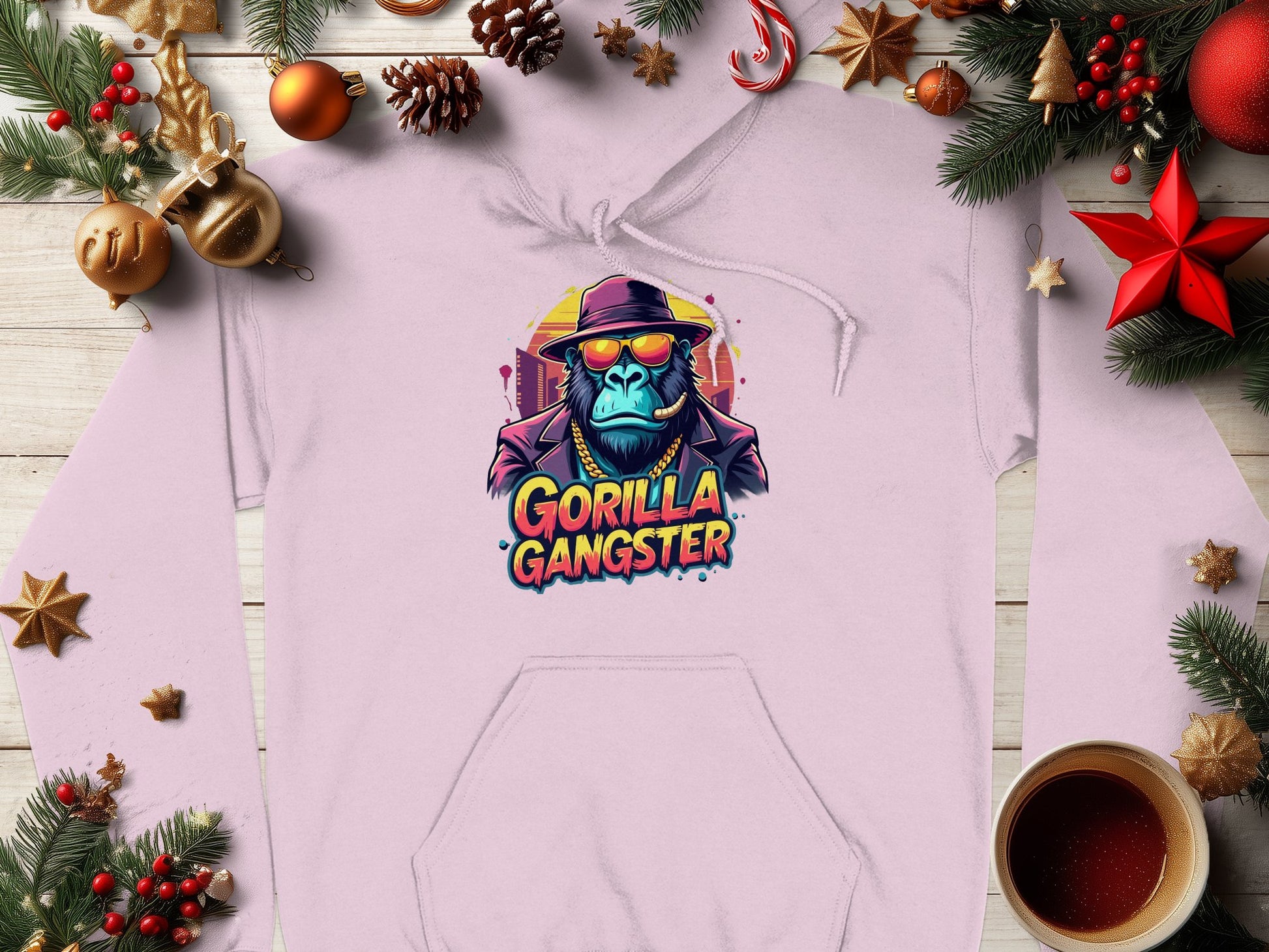 The Garment Graphics streetwear hoodie showcases a gorilla in a hat and sunglasses, tagged Gorilla Gangster, surrounded by Christmas elements like pine branches, ornaments, pinecones, and a coffee cup on wood.