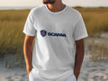 Amidst a sandy landscape with grass, someone wears a stylish white cotton T-shirt branded Garment Graphics, emblazoned with the Scania logo.
