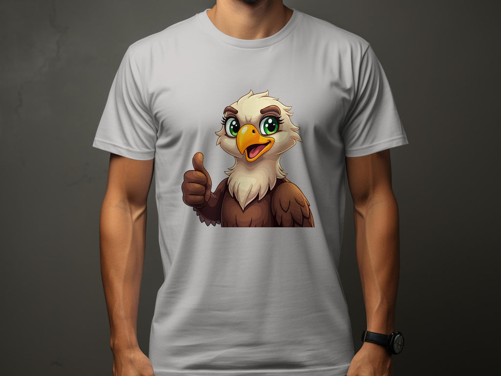 A person wearing a Garment Graphics T-shirt adds a fun casual vibe to any wardrobe with its cartoon eagle featuring large green eyes, a happy expression, and a thumbs-up gesture on a plain dark gray background.