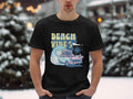 In the snow, someone wears a Garment Graphics t-shirt featuring BEACH VIBES, along with a classic pink car, surfboard, palm trees, and waves.