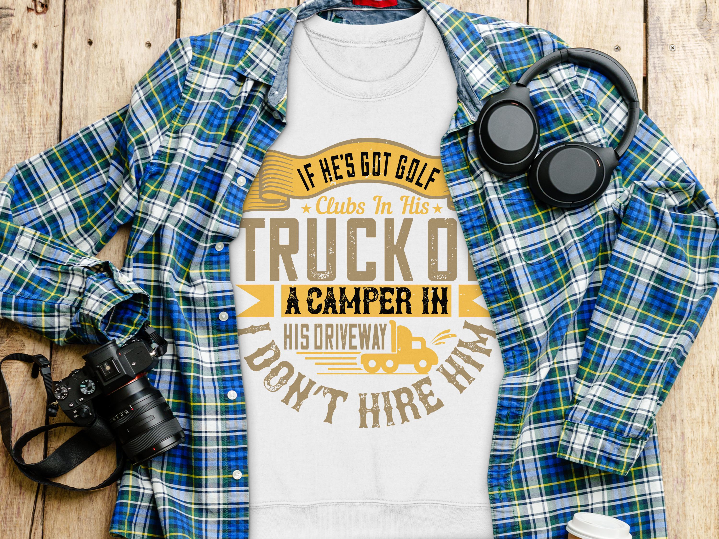 A white Garment Graphics T-shirt with the text If hes got golf clubs in his truck or a camper in his driveway, dont hire him is displayed on a wooden surface. Ideal for outdoor enthusiasts, it’s accompanied by a blue checkered shirt, headphones, and a camera.