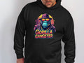 A person in a black Garment Graphics hoodie displays vivid Gorillas Artwork featuring a gangster-styled gorilla. With sunglasses, hat, and cigar, the gorilla captures the streetwear vibe. Gorilla Gangster is prominently shown below.