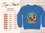 Dog enthusiasts will love this Garment Graphics blue crewneck sweatshirt with a vibrant dog in sunglasses. It features the text Pawsitive Stylish and a charming leaf background. A size chart, from S to 5XL, can be found on the left detailing dimensions in inches.