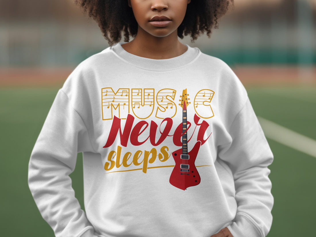A person wears a stylish Garment Graphics sweatshirt featuring Music Never Sleeps and a red electric guitar graphic, ideal for music lovers. The background shows an outdoor setting with blurred elements.