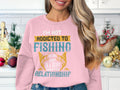 In a festive kitchen, someone wears a Garment Graphics pink sweatshirt with a fishing-themed design and the playful text: Im not addicted to fishing; we are just in a very committed relationship. This cozy piece is available in unisex sizing.